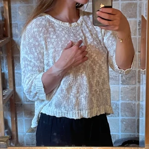 Vit stickad tröja - Säljer en vit stickad tröja med loose passform och trekvartsärm. Tröjan har en unik öppen rygg 