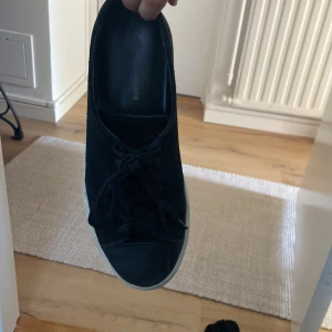 Svarta sneakers från Garment Project - Stilrena svarta sneakers från Garment Project med klassisk rund tå och snörning. Ovandel i skinn och vit platt sula ger en clean look som passar till det mesta. Perfekta för dig som gillar minimalistisk stil.