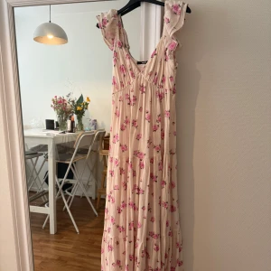 Blommig långklänning - Säljer denna klänningen från bikbok, använd en gång så väldigt fint skick. Passar perfekt till sommaren. 