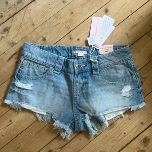 Slutsålda Lågmidjade jeansshorts  - Snygga ljusblå jeansshorts från Gina Tricot med låg midja, slitna detaljer och fransig underkant. Ifrån Gina tricots nya 14+ kollektion och är helt slutsålda på hemsida 😊har kvar prislapp