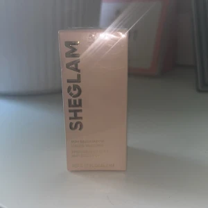 SHEGLAM Sun Beam Matte Liquid Bronzer - Helt ny i obruten förpackning! SHEGLAM Sun Beam Matte Liquid Bronzer i färgen Golden Sun. Flytande bronzer med matt finish, hög pigmentering och lätt att blenda ut. Ger en naturlig, solkysst look. Kommer i en stilren beige förpackning med guldtext. Perfekt för att skulptera ansiktet. 