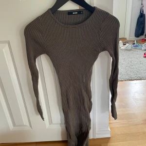 Ribbad grön långärmad klänning BikBok - Säljer en ribbad, tight och långärmad klänning från BikBok i en snygg grön nyans. Klänningen har rund halsringning och är figurnära med stretchigt material, perfekt för dig som gillar en enkel men stilren look.