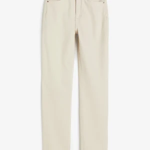 Vita jeansbyxor från H&M - Säljer ett par vita jeansbyxor från H&M. Byxorna har en klassisk design med knapp och dragkedja framtill. Perfekta för en stilren look.