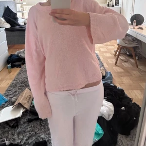 Ljusrosa stickad tröja - Supermjuk och fluffig ljusrosa stickad tröja med rund hals och långa ärmar. . Tröjan har en relaxed passform och är enkel att matcha med både jeans och mjukisbyxor.