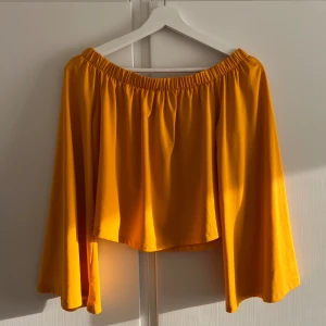 Gul offshoulder topp från Ivyrevel - Säljer en snygg gul offshoulder topp från Ivyrevel. Toppen har vida ärmar och resår upptill som ger en avslappnad och trendig look. Perfekt för vår och sommar!