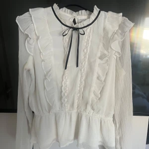 Blus - Blus med rosett och söta detaljer från Lindex!! Det är barnstorlek men skulle säga att den är ungefär som xxs eller xs