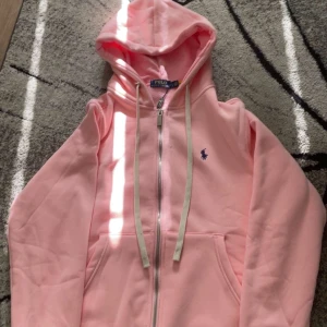 Ralph Lauren - En unik Ralph Lauren zip hoodie i ros färg med skön inre material som passa perfekt till sommaren, passar både till kille och tjej. Hör av er vid minsta fundering OBS: QR kod som tar direkt till hemsidan
