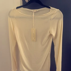 Ljusgul långärmad topp från Missäy - Säljer en ljusgul långärmad topp från Missäy med rund halsringning. Tunn och lätt i materialet, perfekt för lager-på-lager eller som en enkel bas i garderoben. Aldrig använd!
