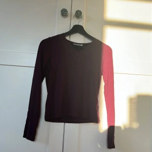 Vinröd långärmad topp med spets från Gina Tricot - Vinröd långärmad topp från Gina Tricot med v-ringning och dekorativ spets längs halsringningen. Mjuk och stretchig, perfekt för lager-på-lager eller som den är. Snygg och enkel att matcha med olika outfits.