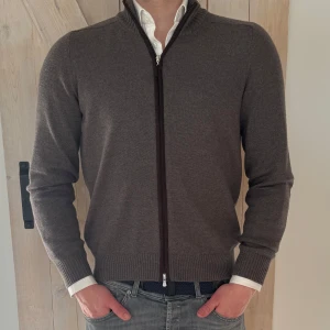 Brun ziptröja från Gran Sasso - Snygg brun ziptröja från Gran Sasso i mjukt material. Tröjan är storlek 48 och skicket är som nytt. Väldigt sparsamt använd