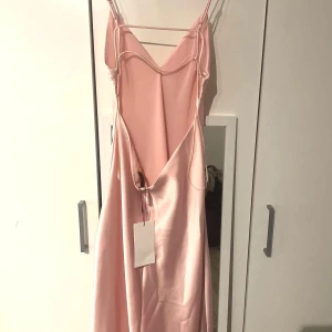 Ljusrosa långklänning i satin med öppen rygg - Säljer en elegant ljusrosa långklänning i satin från ZARA. Den är i storlek M och aldrig använd. Finns dessutom prislapp kvar. Mer ljusrosa i verkligheten🩷Slutsåld på hemsidan 