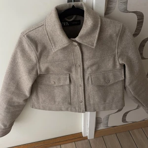 Beige croppad jacka från Zara - Säljer en beige croppad jacka från Zara. Köpt här på Plick därav priset men kan även gå ner vid snabbt köp. Använd ca 15 gånget.
