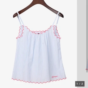 Vit och ljusblå randig linnetopp med volangkant - Sov tröja men man kan också använda den som ett linne! Söt linnetopp med tunna axelband och volangkant i rött längs halsringning och nederkant. Toppen är vit med tunna ljusblå ränder och har en luftig passform. Perfekt för varma dagar! Nypris: 1 300 💝