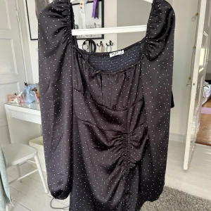 Svart kortklänning med vita prickar från NAKD - Supersnygg svart kortklänning från NAKD med små vita prickar. Klänningen har långa puffärmar, rynkade detaljer framtill och en smickrande passform. Galet snygg klänning och passar perfekt till fest!! Från Ida Carlssons kollektion med NAKD