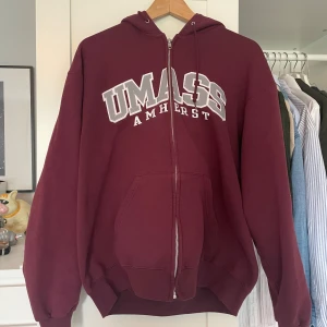 Vinröd vintage hoodie med dragkedja  - Vinröd vintage hoodie med dragkedja och huva från UMass. Köpt i london för två år sen för galet överpris men känns fortfarande som ny.
