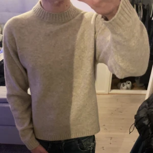 Beige tröja från Uniqlo - Säljer en stilren beige tröja från Uniqlo. Tröjan är tillverkad i en mjuk blandning av akryl och polyester, vilket gör den både bekväm och hållbar. Den har en klassisk rund hals och långa ärmar, perfekt för kyligare dagar. Pris går att diskuteras vid snabba affär🤩