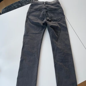 Grå jeans Twig från Weekday - Säljer ett par grå jeans från Weekday, modell Twig. Byxorna har raka ben och v passform i midjan. Perfekta för dig som gillar en enkel och stilren look. 