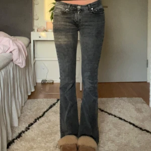 Lågmidjade bootcut jeans  - Lågmidjade bootcut jeans från Gina tricot i storlek 32. Grå / svarta i färgen. Dom är uppsprättade längst ner och passar mig som är ca 169 i längden💕