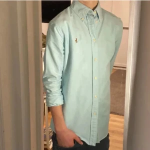 Ralph Lauren Skjorta - Tja säljer en Ralph Lauren skjorta i färgen ljusblå/turkos och storlek s passar 165-175 cm ungefär nypris 1595kr mitt pris 229kr. Inga defekter som hål eller fläckar. Skriv vid fråga eller fundering