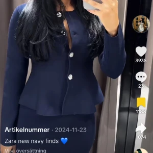 Populärt set från Zara  - Snygg mörkblå kostym från Zara med figurnära kavaj och matchande kjol. Kavajen har dekorativa, glittriga knappar framtill och en lätt peplumformad midja. Perfekt för dig som vill ha en stilren och trendig look. Setet är slutsålt och har prislappen kvar. Säljer för att det inte är min stil. 