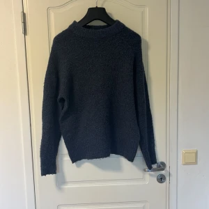 Mörkblå stickad tröja från lager 157 - Mysig mörkblå stickad tröja från lager 157 med rund halsringning och lång ärm. Perfekt för kyliga dagar och enkel att matcha med olika outfits. Tröjan har en klassisk, rak passform och är tillverkad i ett mjukt material.