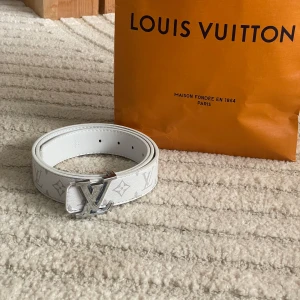 Vit Louis Vuitton monogram skärp  - Säljer ett vitt Louis Vuitton bälte i skinn med klassiskt monogrammönster och ett stort LV-spänne i silver. Bältet har flera hål för justering och är tillverkat i Spanien. Perfekt accessoar för att lyfta din outfit.🩶🤍🩶🤍BÄTTRE PRIS - SNABB AFFÄR 