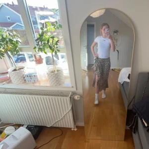 Leopardmönstrad omlottkjol - Säljer en snygg leopardmönstrad omlottkjol med knyt i midjan. Kjolen är i midi-längd och har en lätt volangkant nedtill. Perfekt för dig som vill sticka ut lite extra med ett trendigt djurmönster.