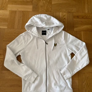 Vit hoodie med dragkedja från Lyle & Scott - Säljer en vit hoodie från Lyle & Scott med dragkedja och huva. Den är i pra skick. Ställ frågor!