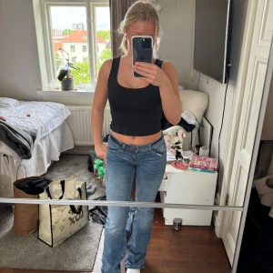 Blåa botcut jeans - Säljer mina blåa botcut jeans från hm med detaljer på bakfickorna 