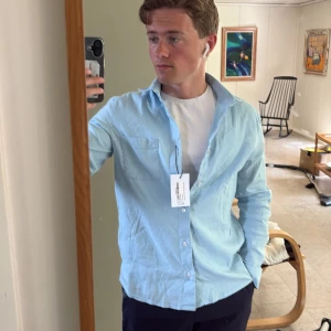 Linneskjorta - Jättesnygg icke-använd  ljusblå linneskjorta från shaping new tomorrow. Lappen e fortfarande kvar å aldrig tidigare använd. Nypris ligger på runt 1199kr och skicket är givetvis 10/10. Perfekt till sommaren å går utmärkt å matcha me både jeans å linnebyxor å badbyxor