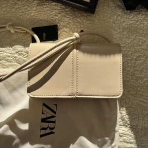 Helt ny väska från Zara - Säljer denna fina beige/vita axelväskan från Zara. Köpte den förra året för 500kr o den är helt ny 🤍