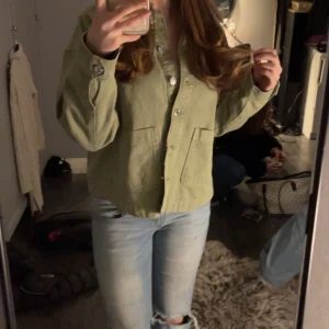 Grön jeansjacka  - Snygg grön jacka med knappar framtill och två stora fickor. Perfekt för en avslappnad stil. Jackan har en normal passform och långa ärmar. SLUTSÅLD