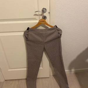 Svartvita byxor från Esmara - Snygga svartvita byxor från Esmara med ett klassiskt rutigt mönster. Byxorna har en normal passform och är perfekta för en stilren look. De är tillverkade i ett bekvämt material som passar bra för både vardag och mer uppklädda tillfällen.