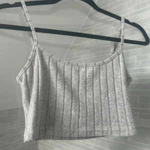 Grå ribbad linnetopp från Shein - Säljer en stilren grå ribbad linnetopp från Shein. Toppen har smala axelband och en croppad passform, perfekt för varma dagar. Enkel och snygg att matcha med olika outfits.