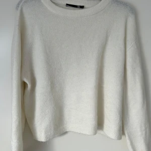 Vit stickad tröja från 157 - Säljer en stilren vit stickad tröja från 157. Tröjan har en rund halsringning och långa ärmar, perfekt för kyligare dagar. Den är mjuk och bekväm, idealisk för en avslappnad look.