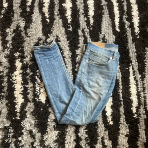 Blåa Dondup George Jeans - Säljer ett par snygga blå jeans från Dondup. Använda fåtal gånger med ett mindre defekt på knät som inte syns alls när man bär eller på bilder. De är också stretchy. 