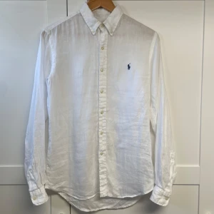Ralph lauren linne skjorta. - Säljer en stilren vit skjorta. Denna är använd 2-3 gånger och har dessutom kvar en lapp. Köpt från zalando.se för 2000kr. Denna skjorta är i ny skick. Storlek är 18-20 vilket motsvarar S. Är 176-177 och den passar mig bra.