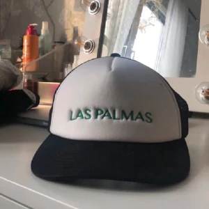 Keps - Säljer en vit keps med svart nät och grönt tryck på framsidan💚 från Monki. Storleken kan justeras med hjälp av knapparna där bak. Defekt på sista bilden.