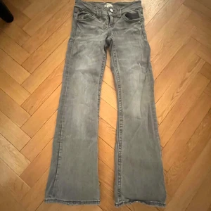 Grå jeansbyxor - Snygga grå jeansbyxor med bootcut-stil. De har en klassisk femficksdesign och knappar i midjan. Perfekta för en avslappnad look.