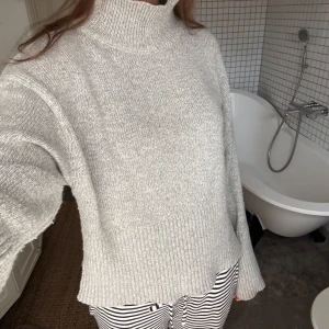 Grå stickad polotröja - Säljer en stilren och snygg grå stickad polotröja med ribbade detaljer vid ärmslut och nederkant. 