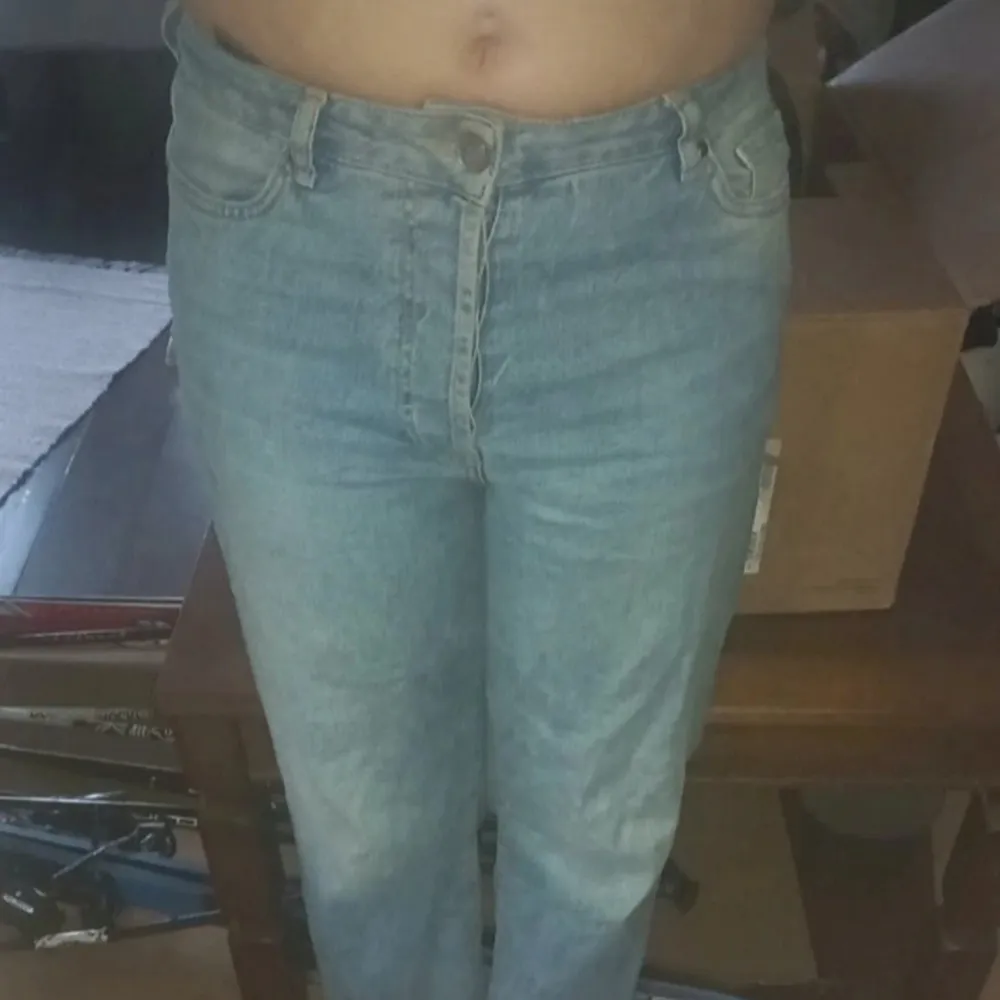 Säljer ett par klassiska blå jeansbyxor med en normal passform. De har en traditionell femficksdesign och knappgylf. Perfekta för en avslappnad stil. Jeansen är högmidjande.. Farkut & Housut.