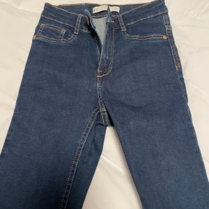 Blå jeansbyxor / Molly jeans från Gina tricot - Snygga blå jeansbyxor med klassisk design och kontrasterande sömmar. De har en dragkedja och knapp framtill samt fem fickor. Perfekta för en avslappnad stil.