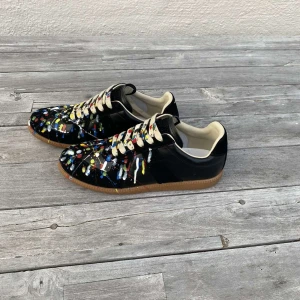 Maison Margiela skor - Maison Margiela paintsplater sneakers i topp skick. Skorna är extremt sparsamt använda box och sko påsar ingår. Storlek 42 men passar 41-43. Skriv privat för fler bilder och vid minsta fundering. Kan gå ner i pris vid snabb affär😊