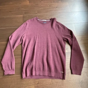 Vinröd tröja från Lindbergh - Säljer en stilren vinröd tröja från Lindbergh med ett diskret mönster. Tröjan har långa ärmar och rund halsringning, perfekt för en avslappnad look. Passar bra till både jeans och chinos.