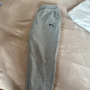 Grå mjukisbyxor från Puma - Säljer ett par grå mjukisbyxor från Puma. Perfekta för en avslappnad stil eller träning. Bra skick, passar både dam och herr