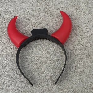 Diadem med röda horn kan lysa!! - Coolt diadem med röda horn, perfekt för en utklädnad eller fest. Diademet är svart och har en knapp för att aktivera ljus i hornen. Ett roligt tillbehör för att sticka ut i mängden!
