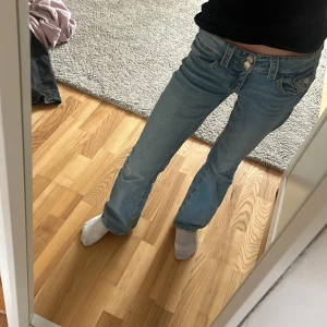 Blå jeans från Gina Tricot - Snygga blå jeans från Gina Tricot i en klassisk design. De har en låg midja och en straight passform. Perfekta för en avslappnad stil. Jeansen har knappar och en liten ficka fram.
