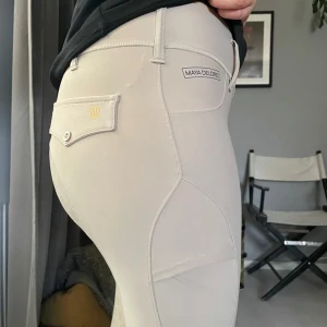 Beige ridbyxor från Maya Delorez - Snygga beige ridbyxor från Maya Delorez med hög midja och tight passform. Byxorna är helskoda och är i väldigt bra skick 