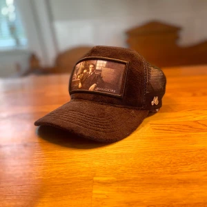 Svart keps från Maggiore - Ny pris 600 använd endast 4 gånger Snygg svart keps från Maggiore med ett unikt tryck framtill. Kepsen har ett nätmaterial på baksidan för bättre ventilation och en justerbar passform. Perfekt för en cool och avslappnad stil.