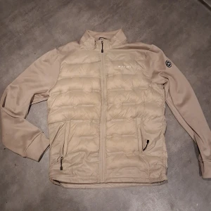 Beige cardigan från Marine - !Pris är inte helt satt! Säljer en snygg beige cardigan från Marine. Jackan har en dragkedja framtill och två praktiska fickor med dragkedjor. Perfekt för kyligare dagar med sin quiltade design och långa ärmar.